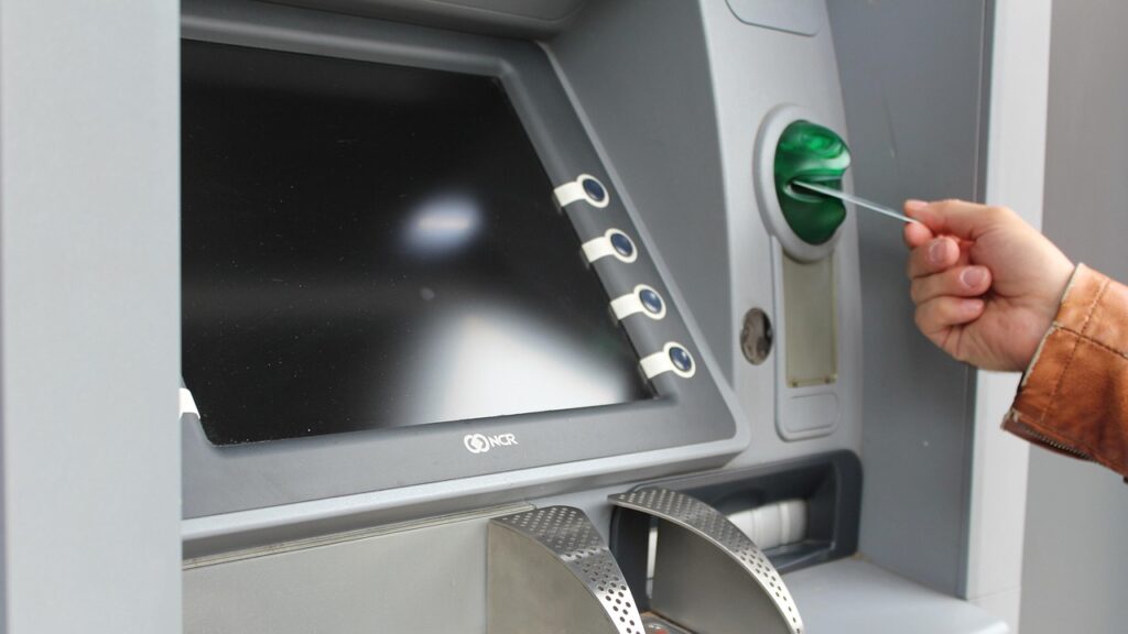 a person using a credit card to insert a card into an atm