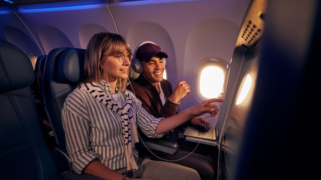 a man and woman sitting in an airplane