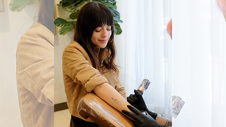 a woman getting a tattoo on her arm