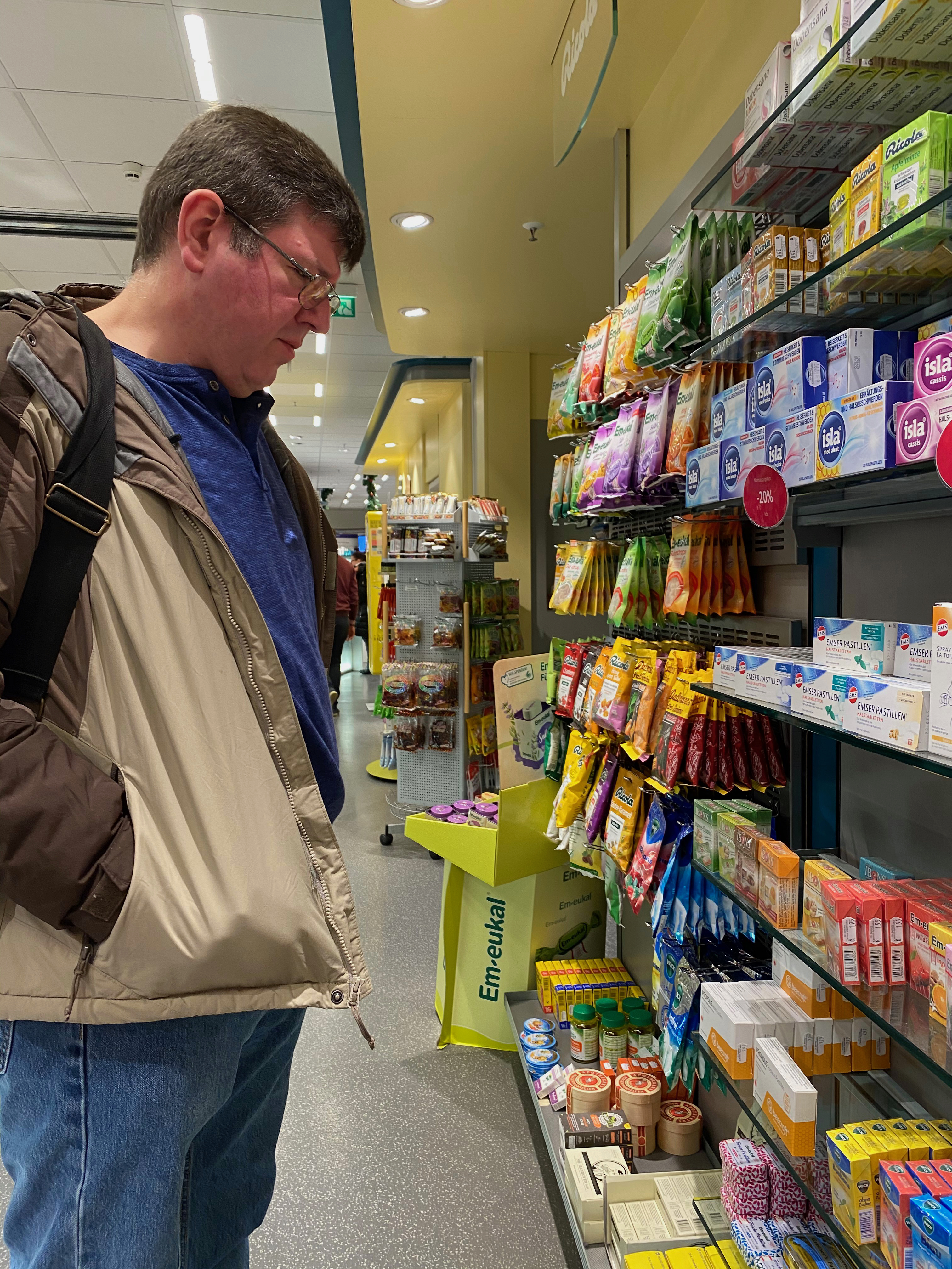 a man looking at a shelf of medications