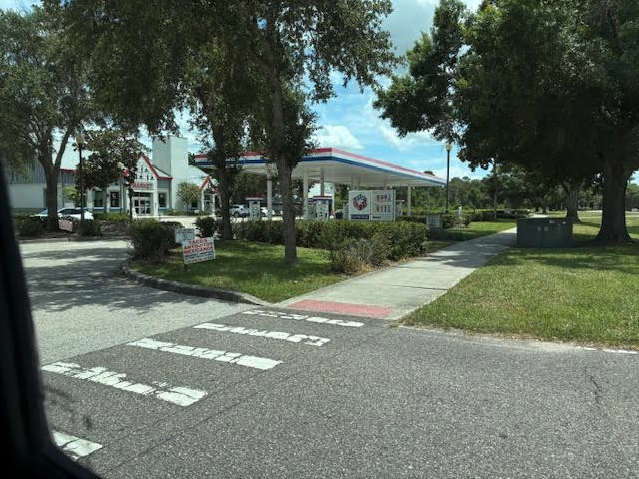 a gas station with a building and trees