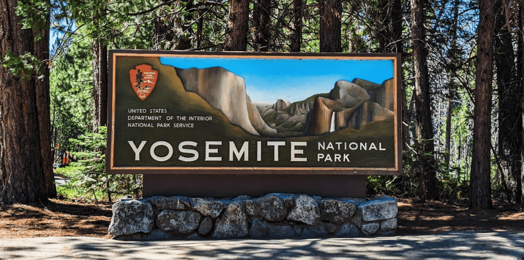 a sign with a picture of mountains and trees