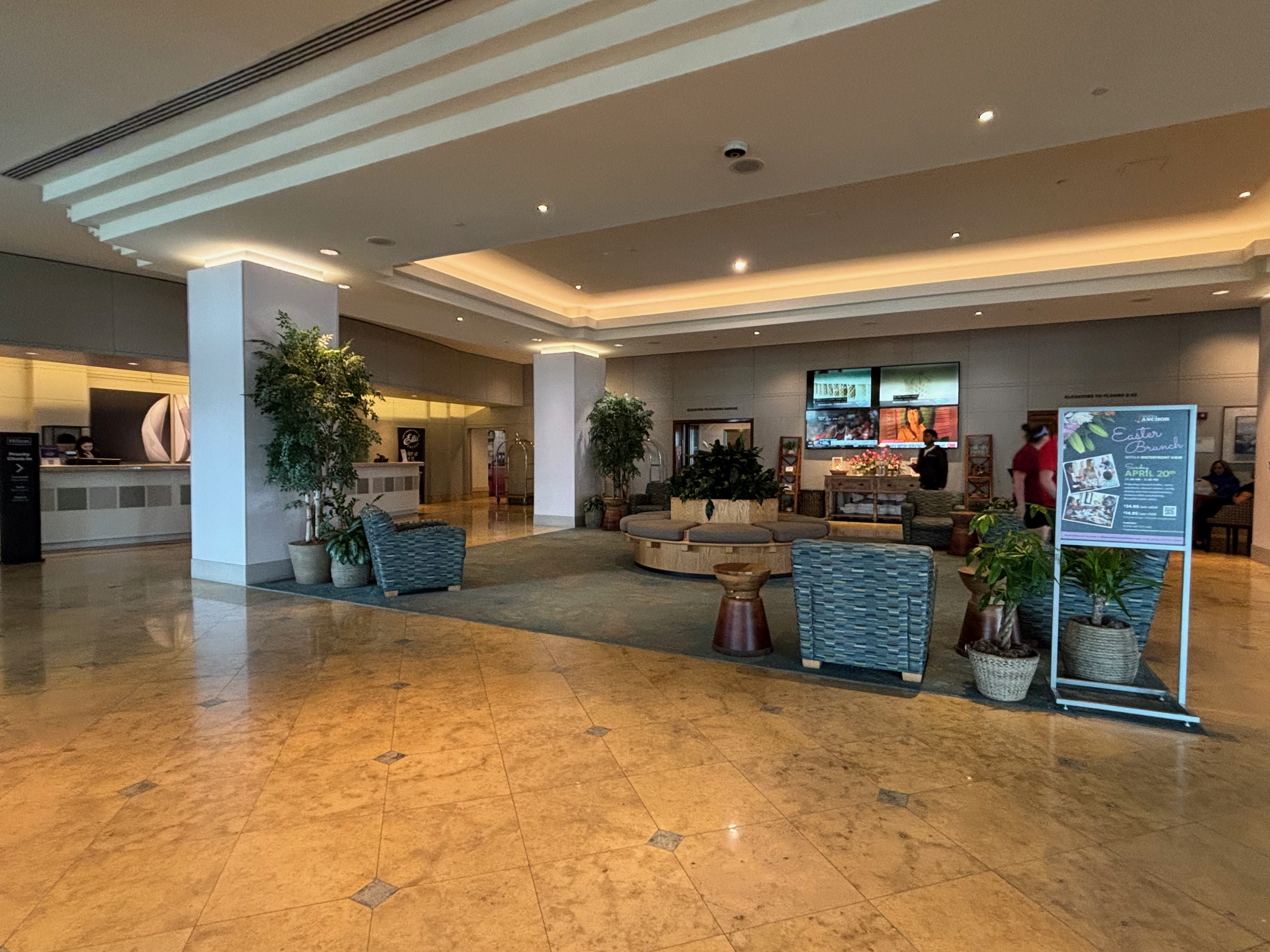 a large room with a large sign and plants
