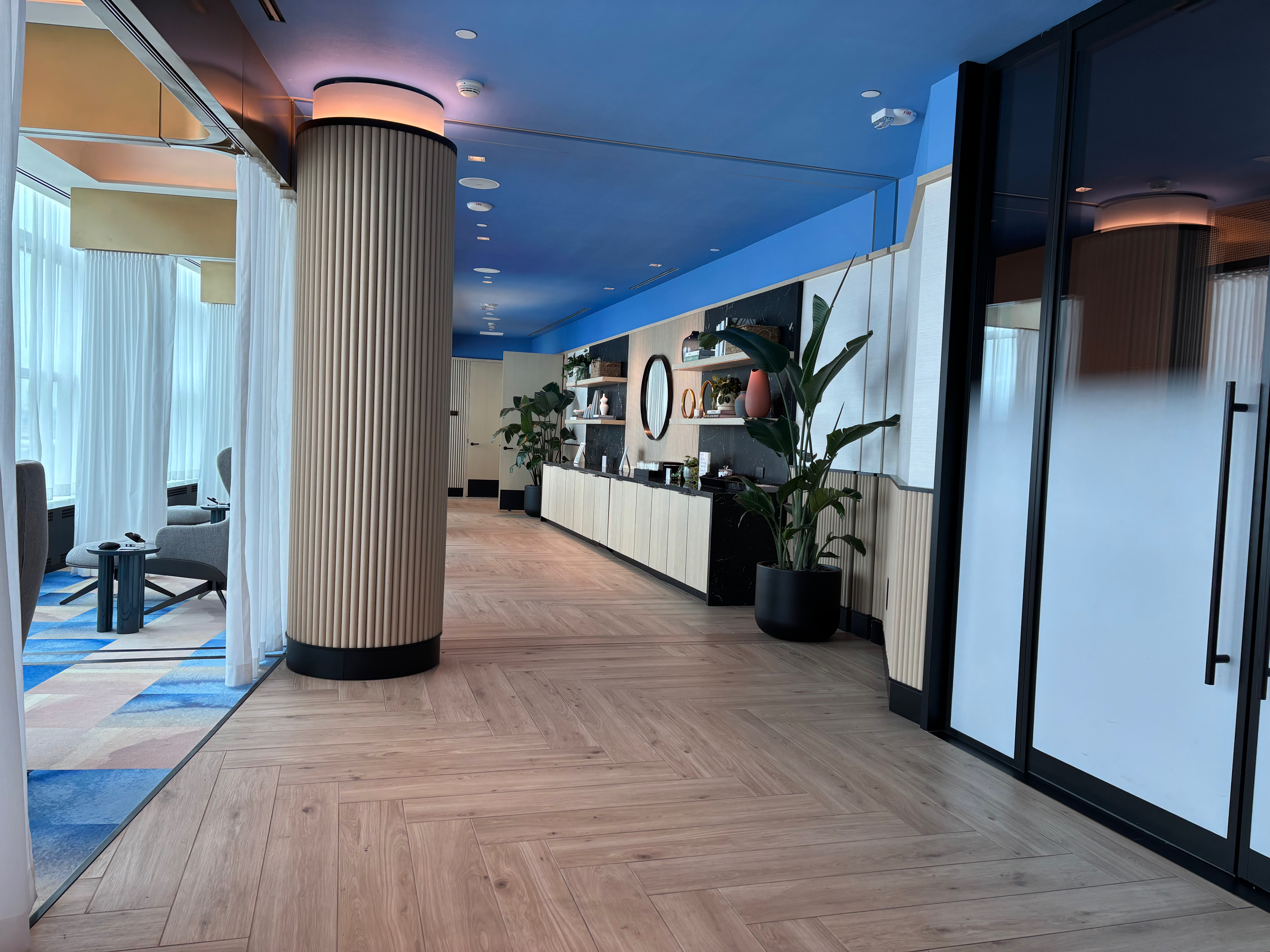 a hallway with a blue ceiling and a wood floor