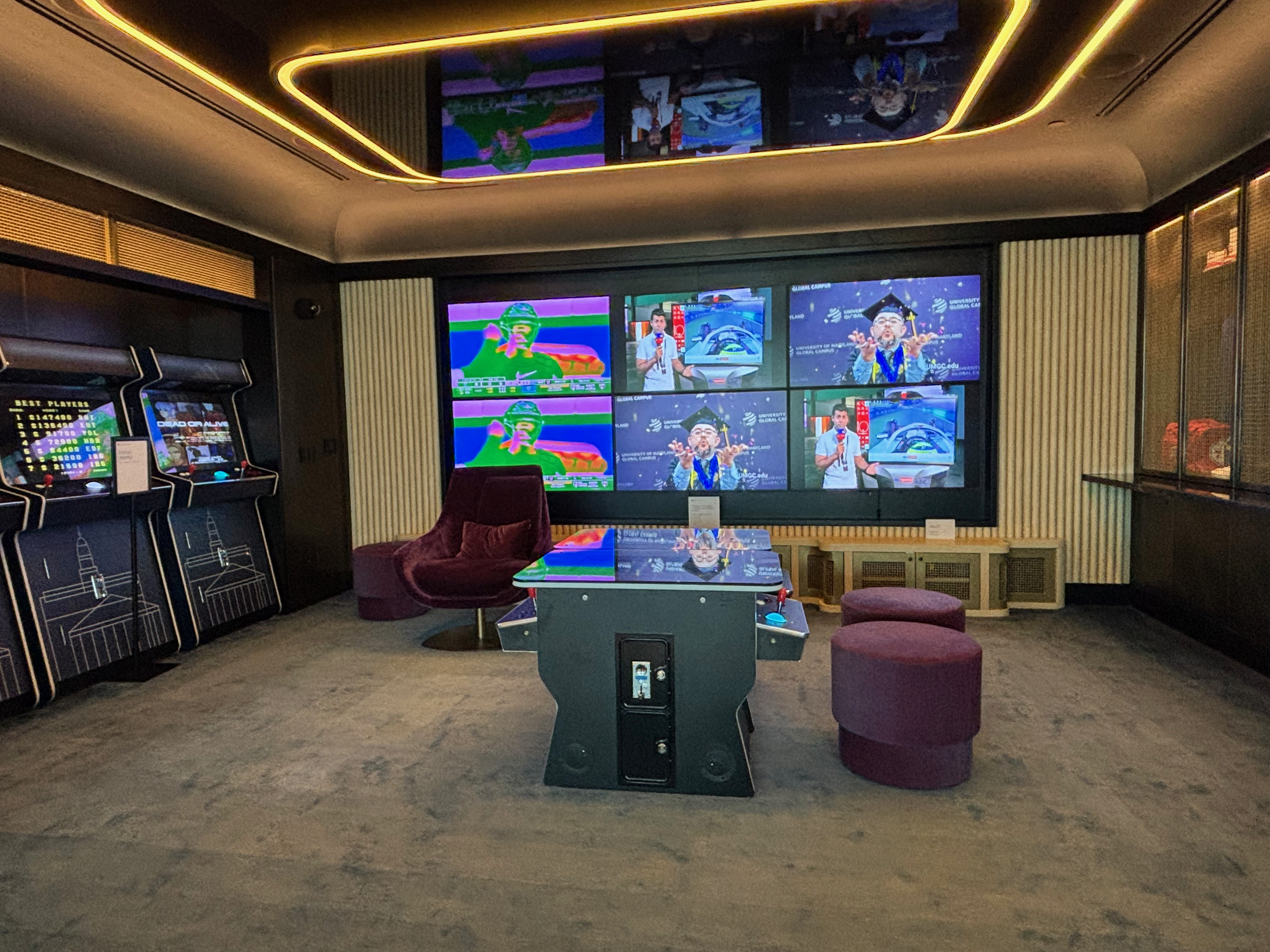 a room with a table and chairs and a large screen
