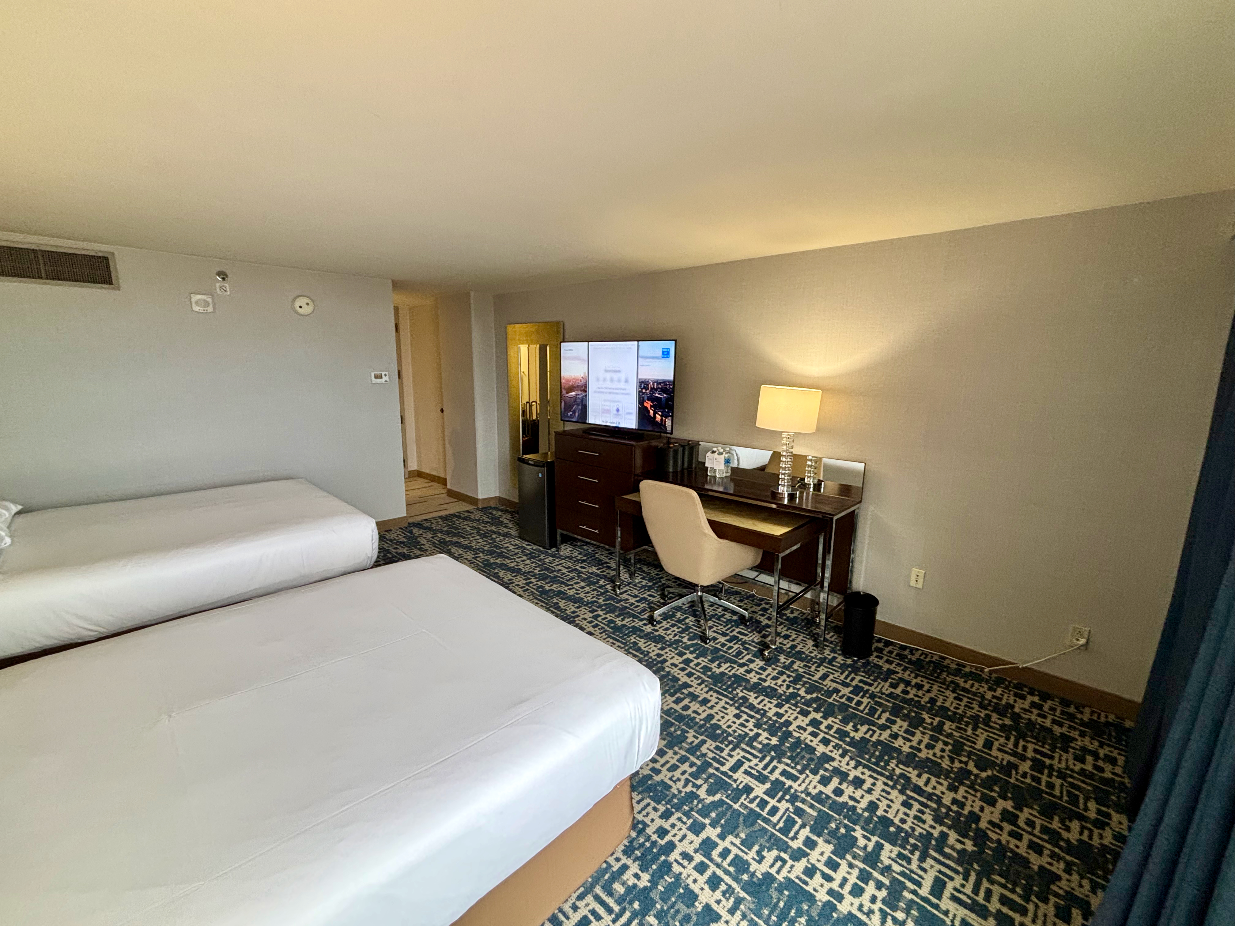 a room with two beds and a desk