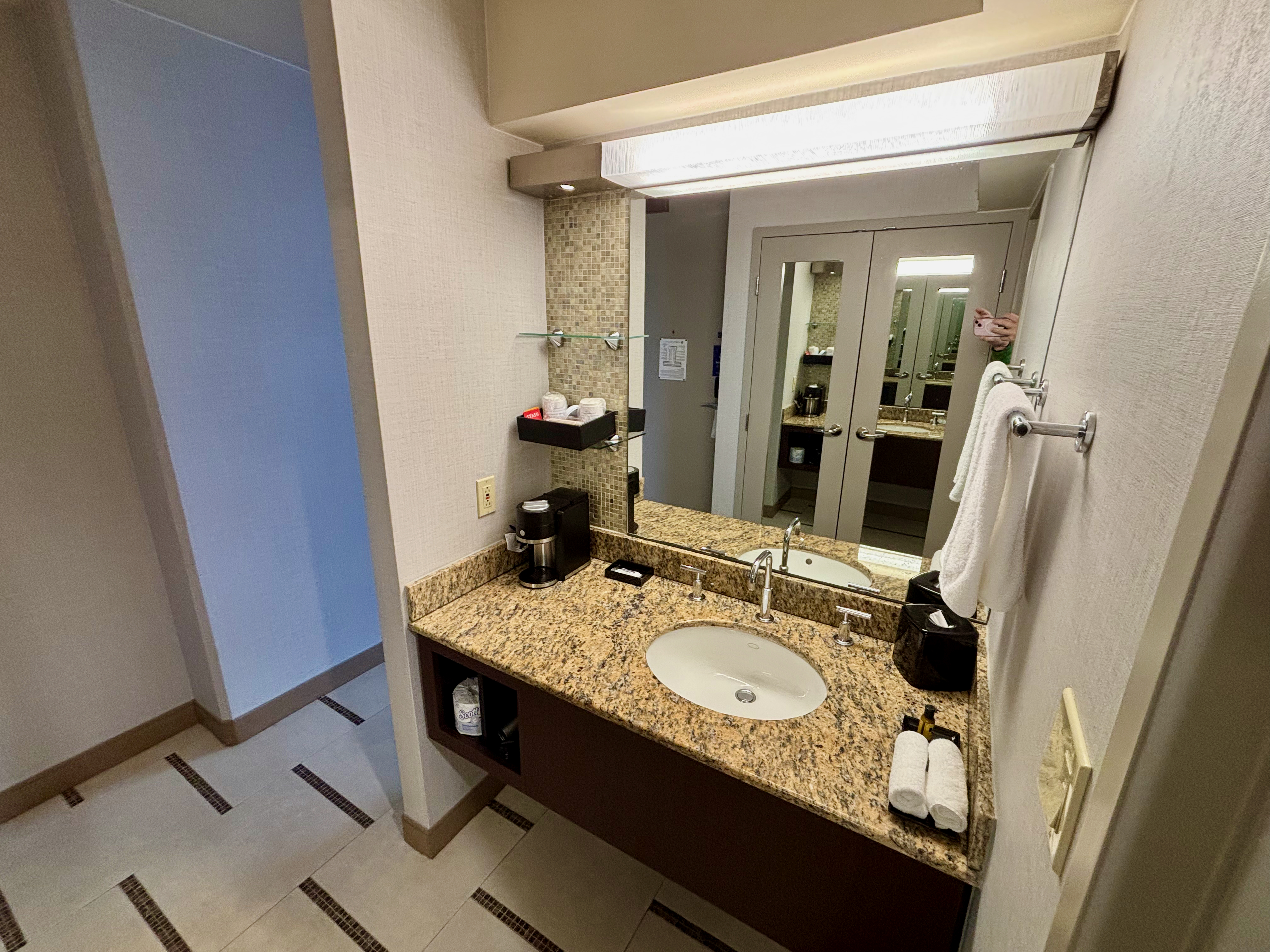 a bathroom with a marble countertop and a mirror