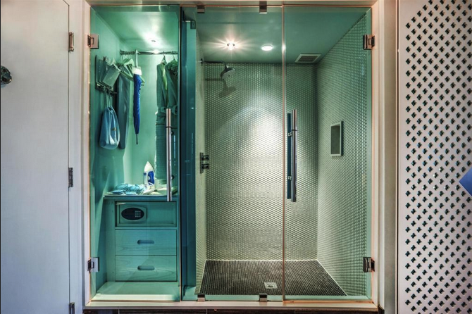 a glass shower with a sink and a mirror