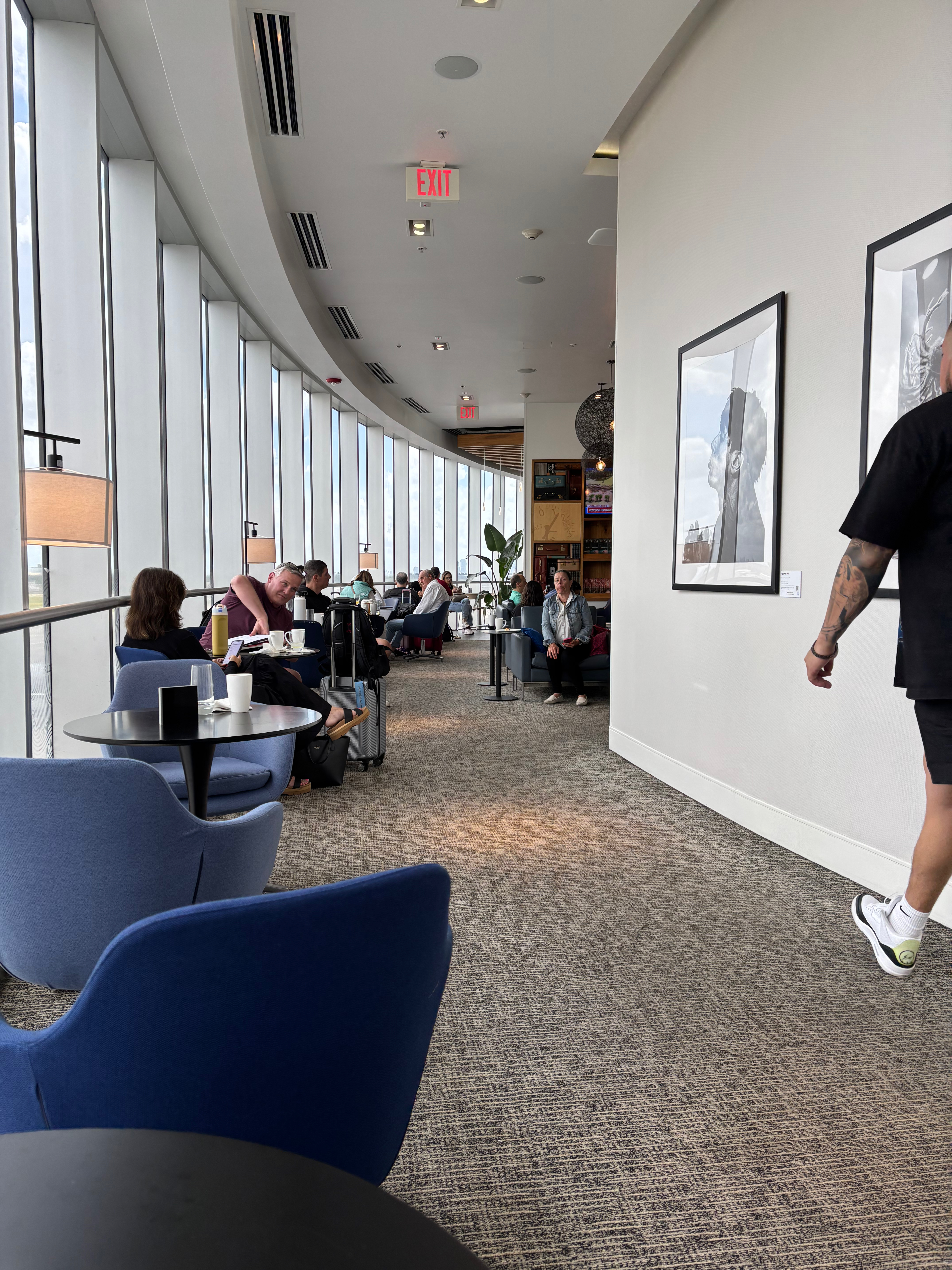 a room with a large window and people sitting around