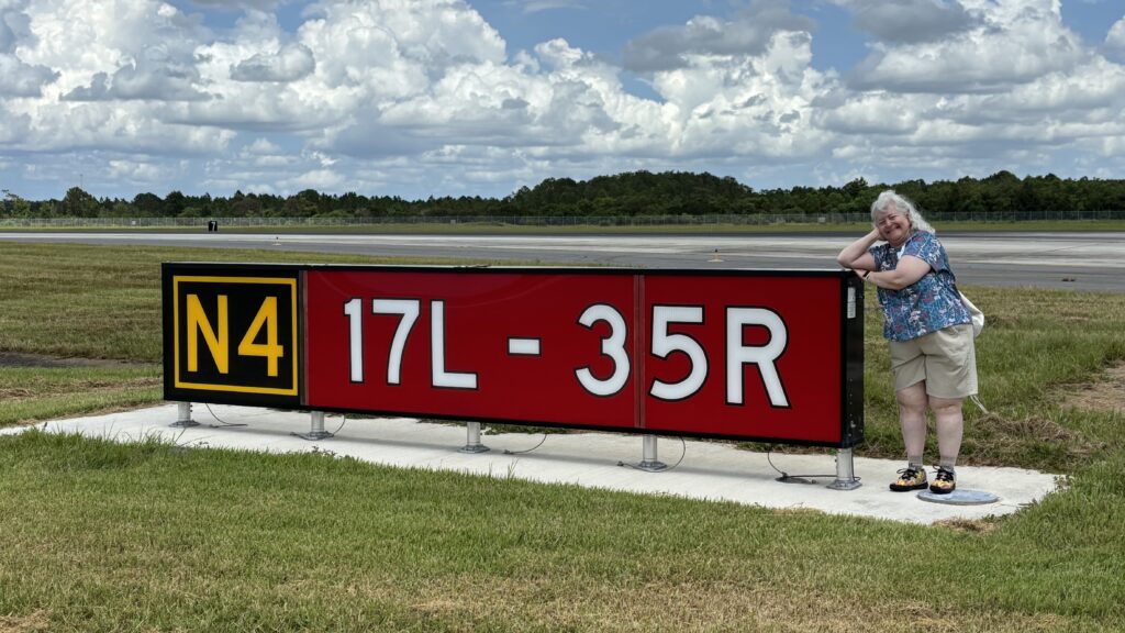 a woman standing next to a sign