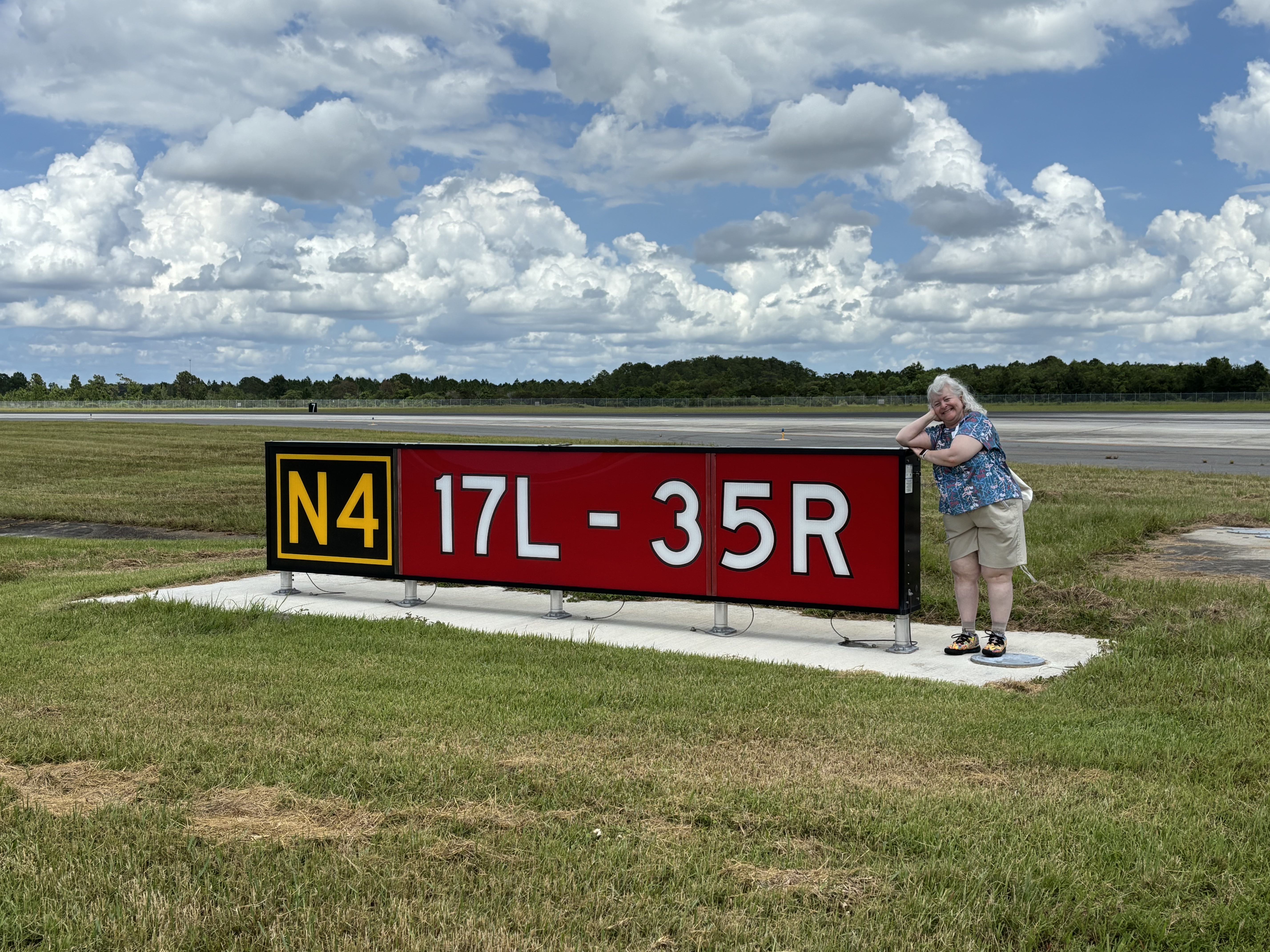 a woman standing next to a sign