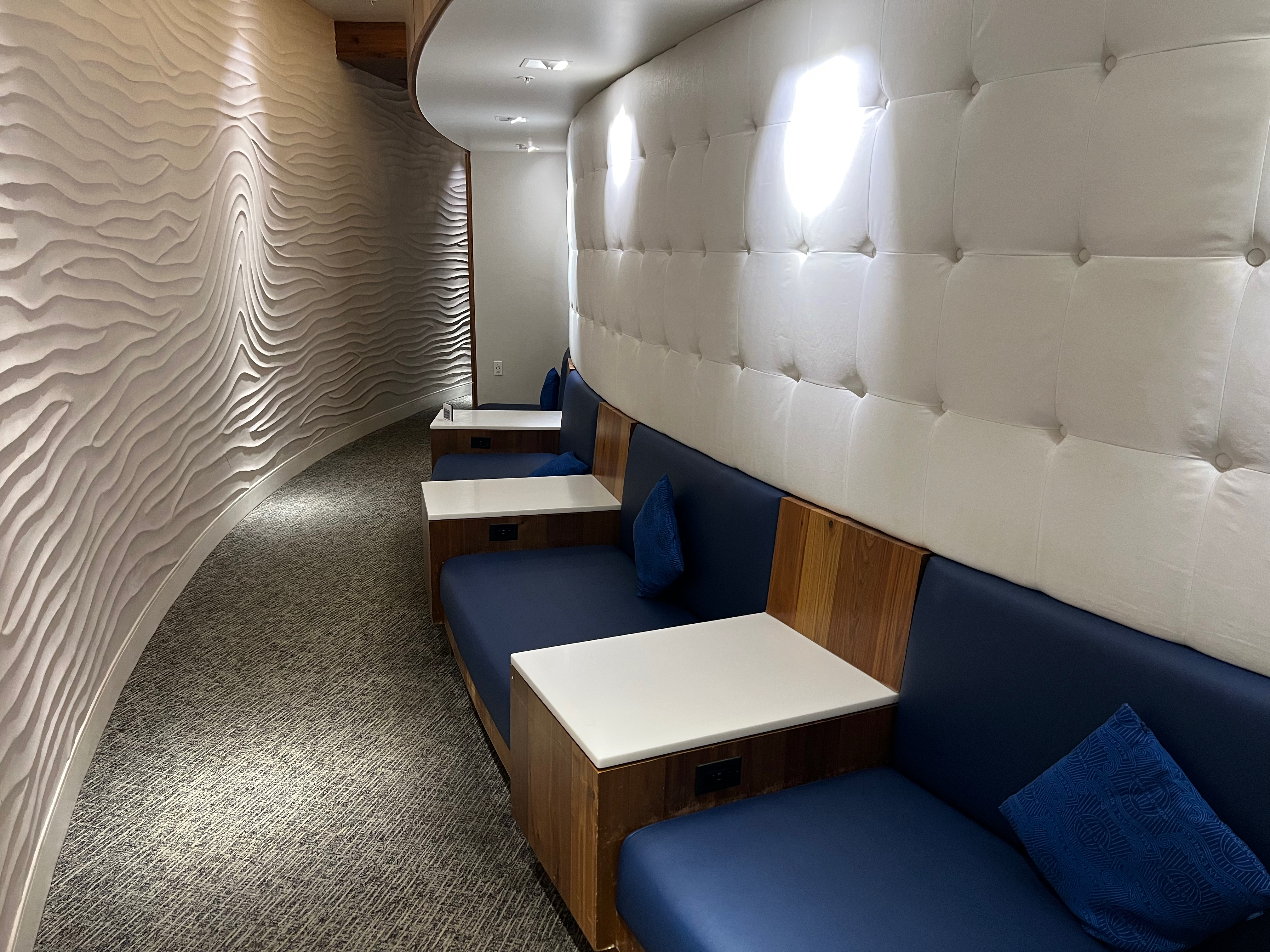 a long hallway with blue couches and white walls
