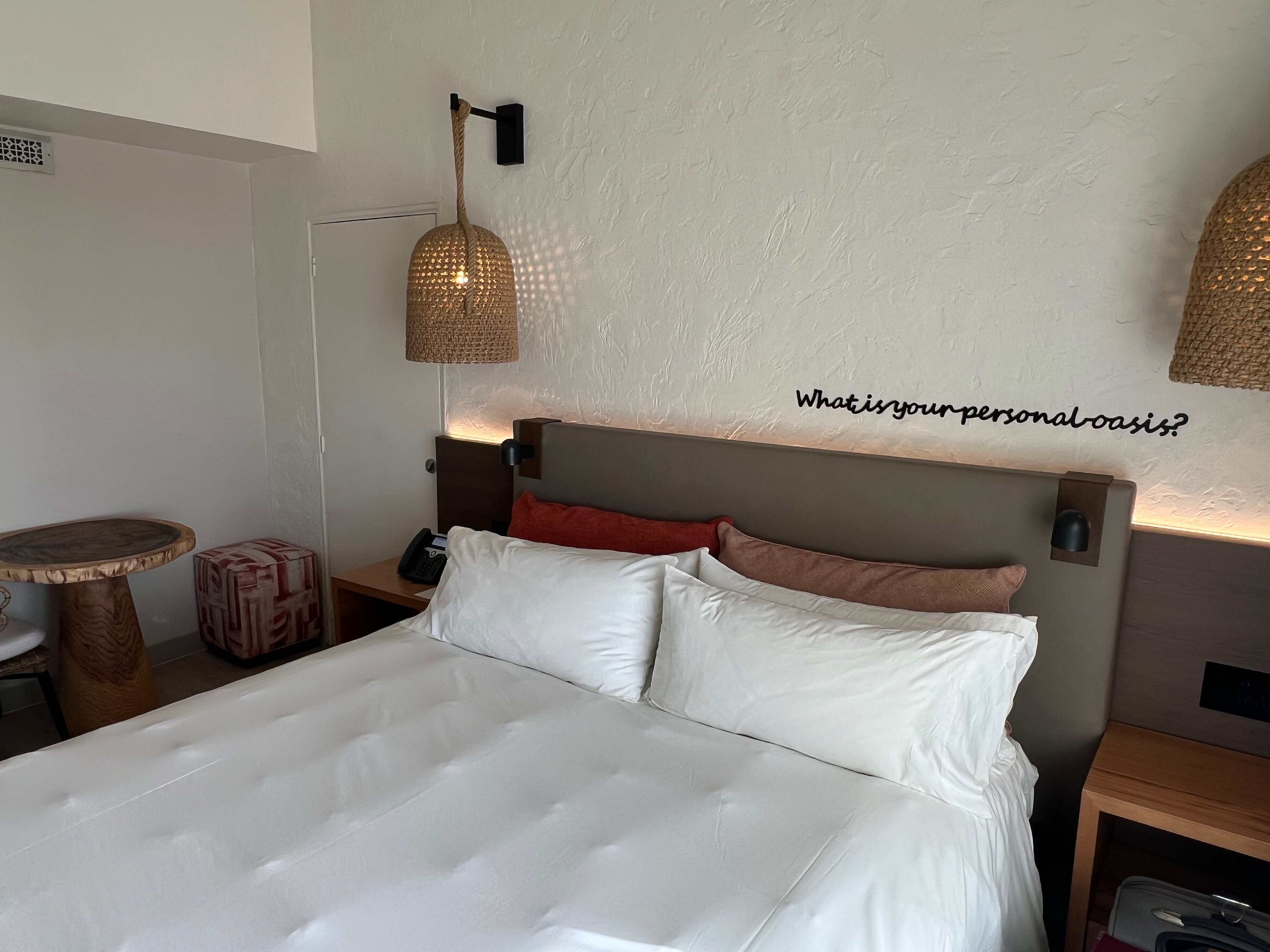 a bed with white sheets and a lamp