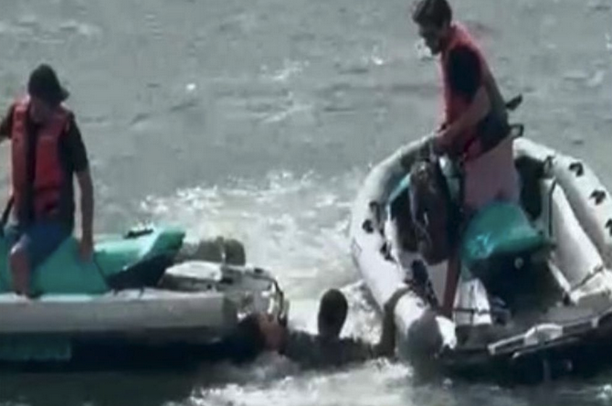 a man in a raft with another man in the water