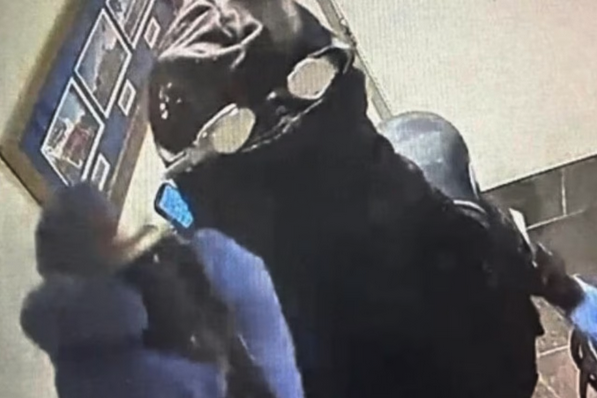 a person wearing a black mask and sunglasses