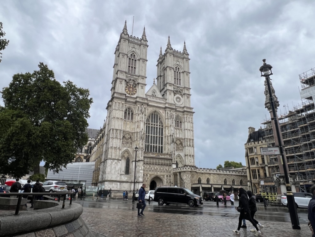 a large building with towers and people walking around