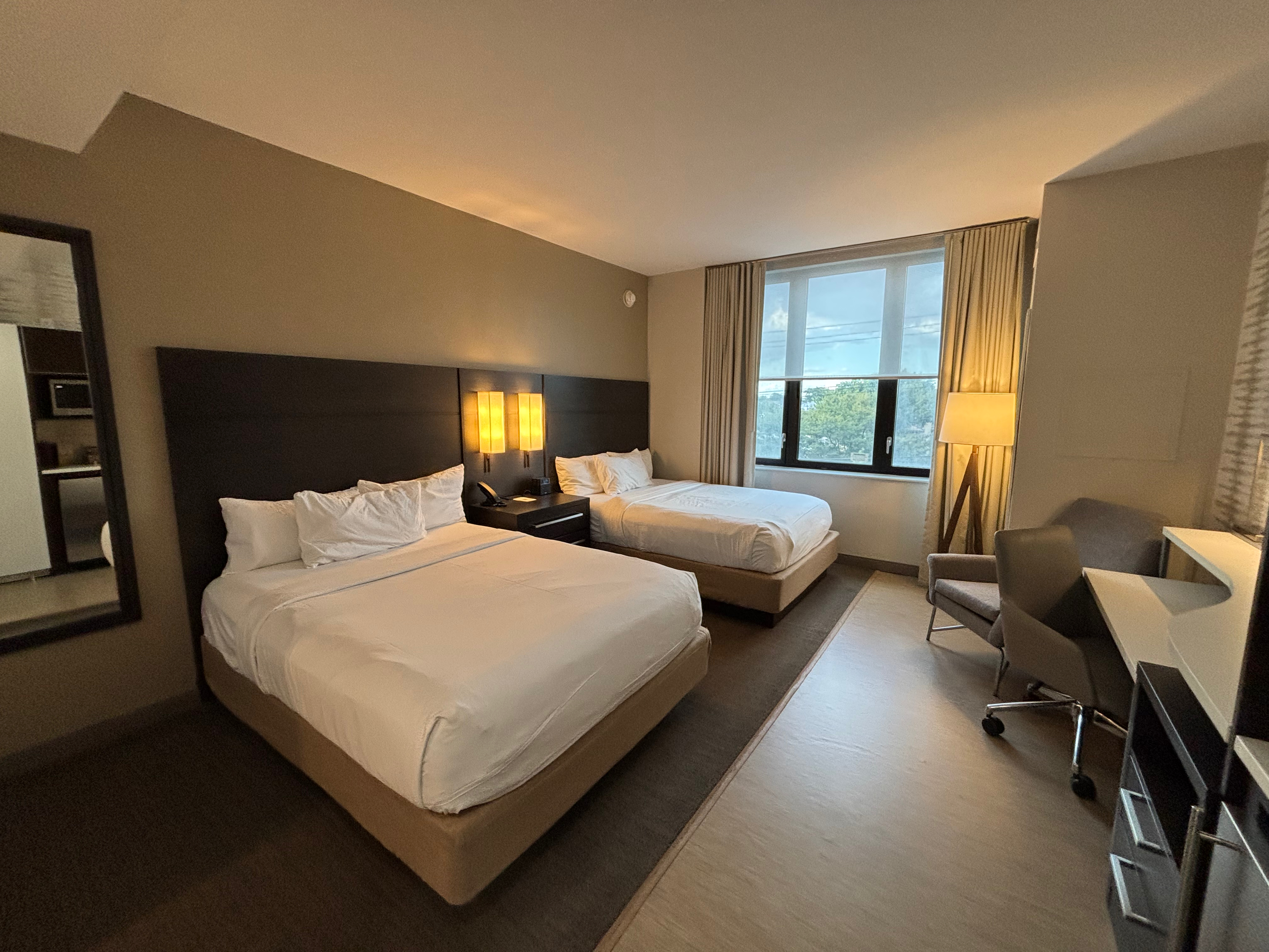 a room with two beds and a desk