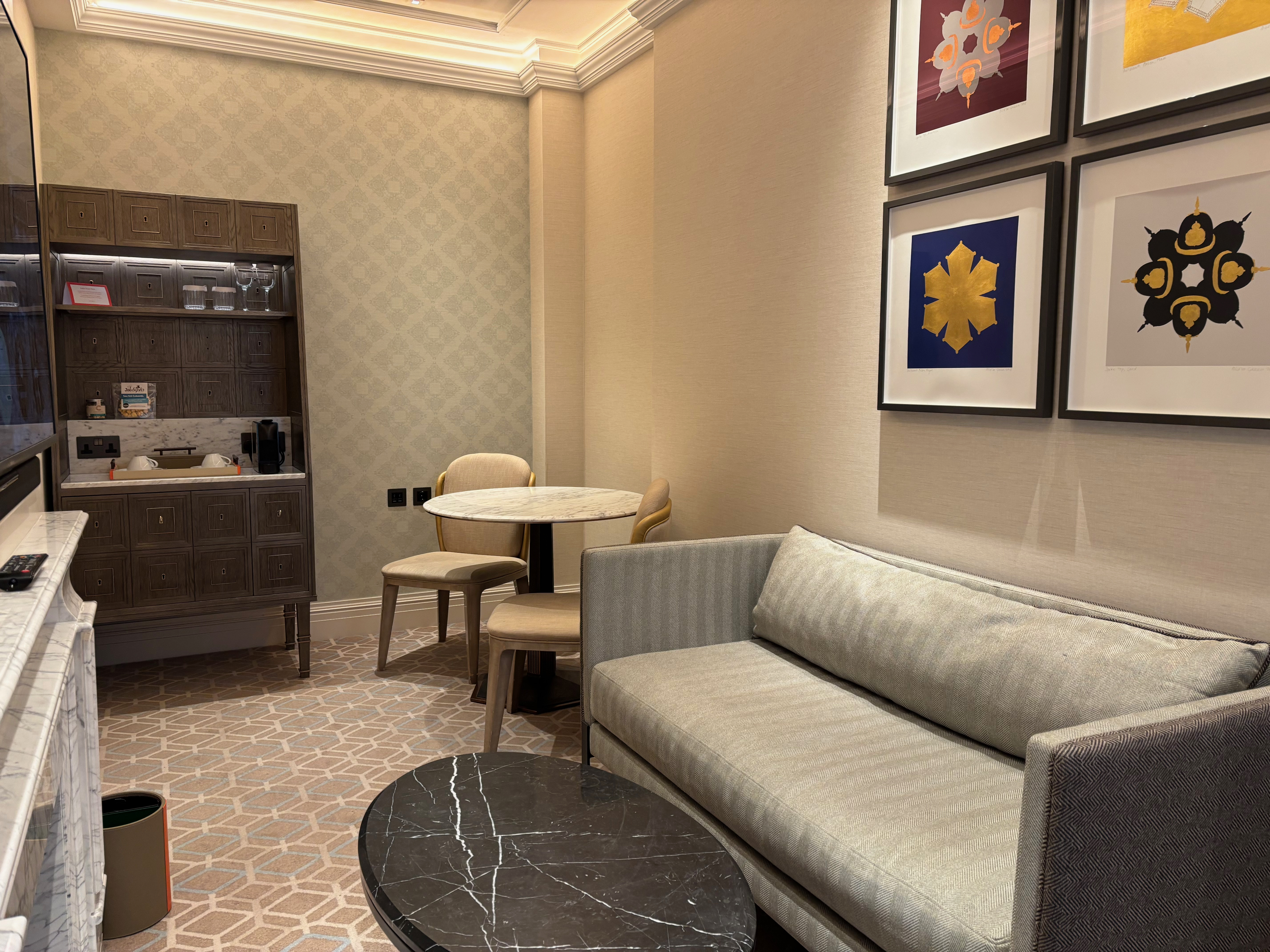 a room with a couch and tables and artwork on the wall