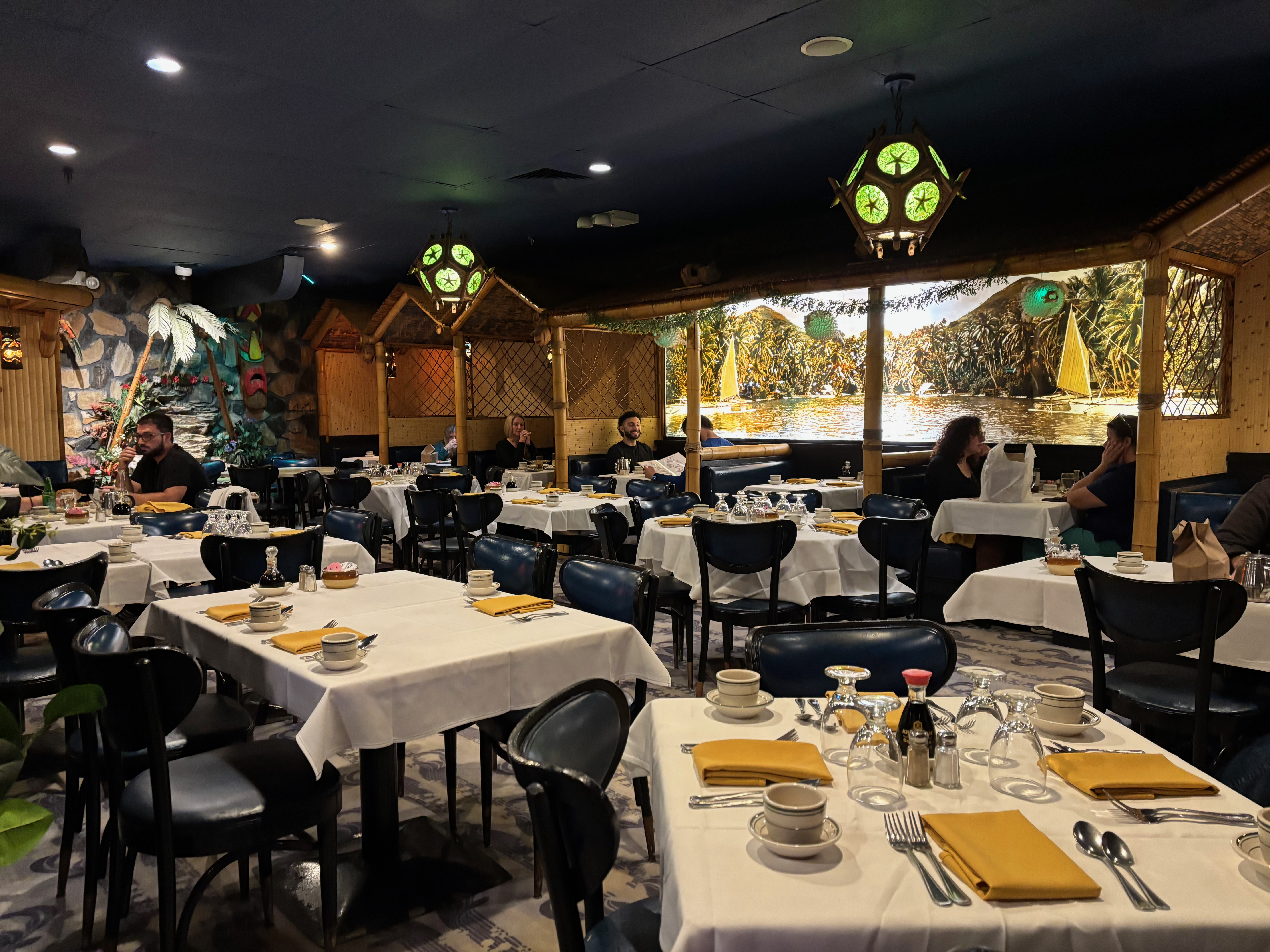 a group of people sitting at tables in a restaurant
