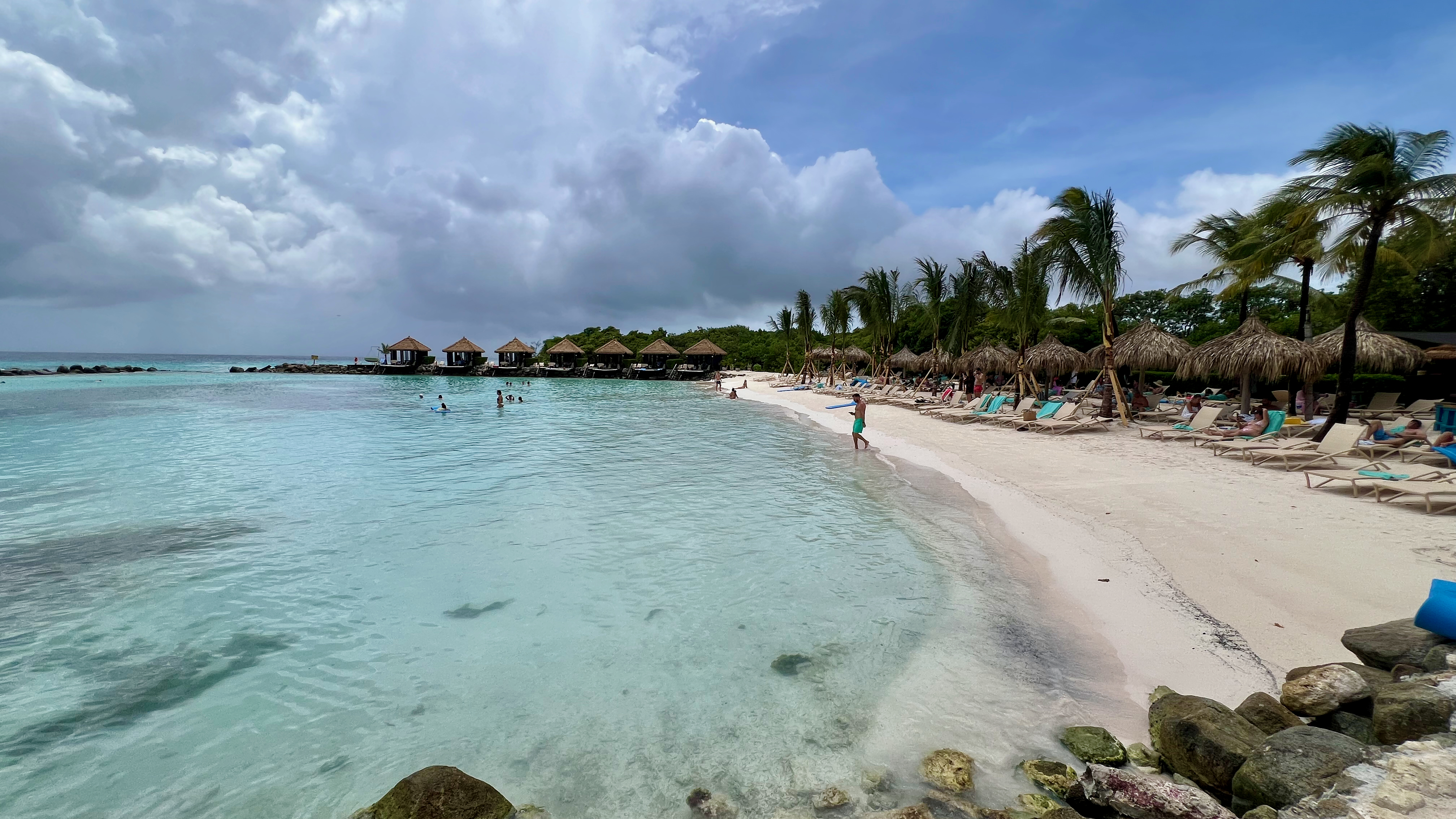 a beach with people on the water