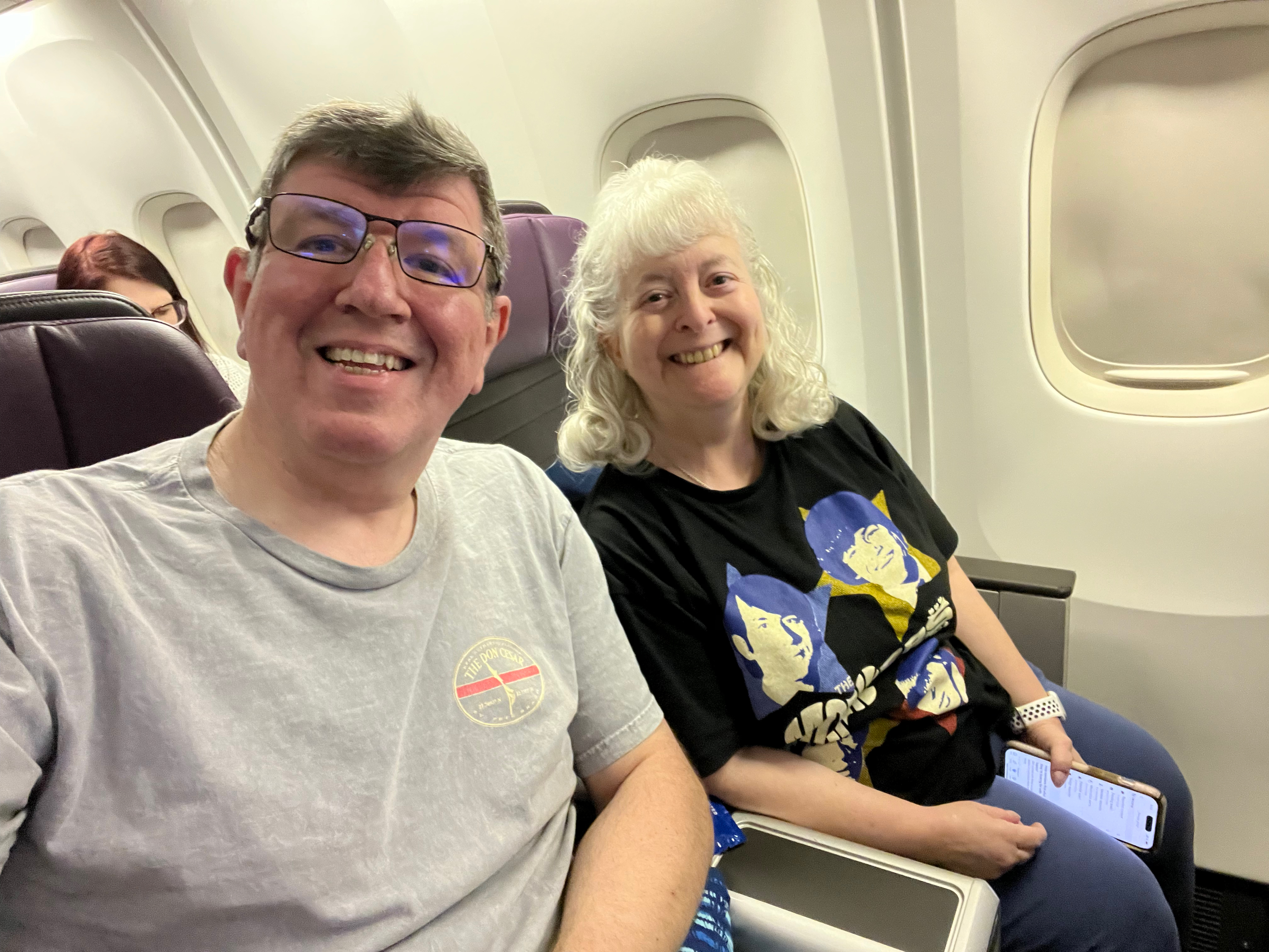 a man and woman sitting on an airplane