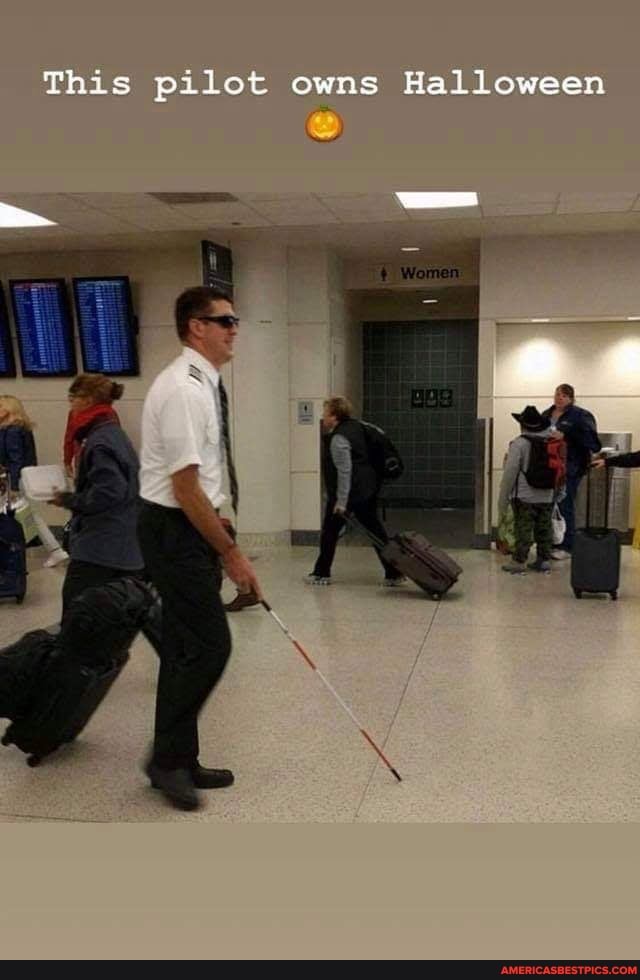 a man with a cane walking with luggage in an airport