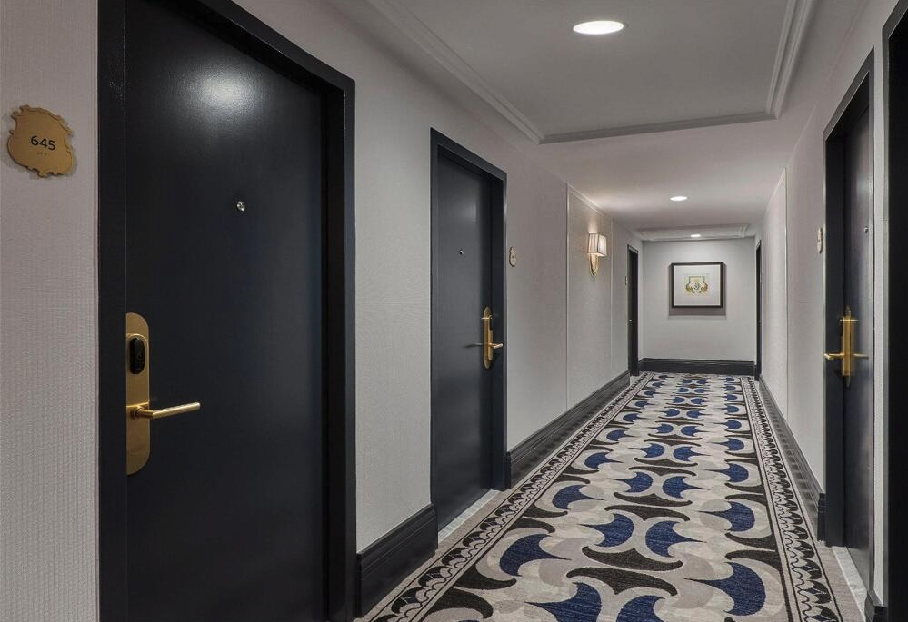 a hallway with black doors and a patterned carpet