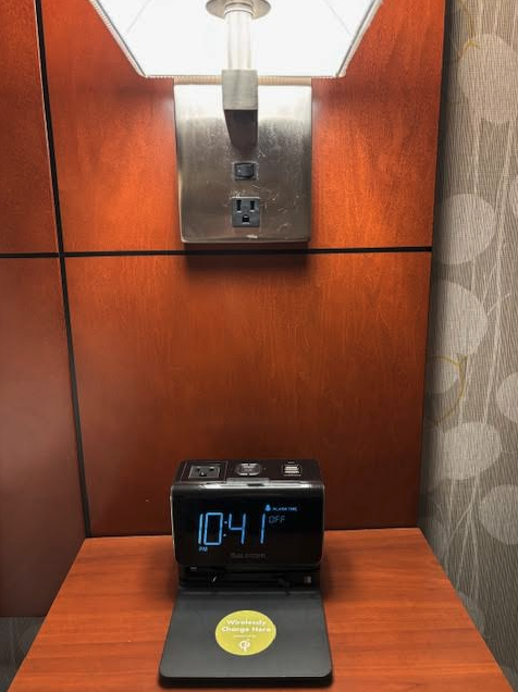 a black alarm clock on a wood surface