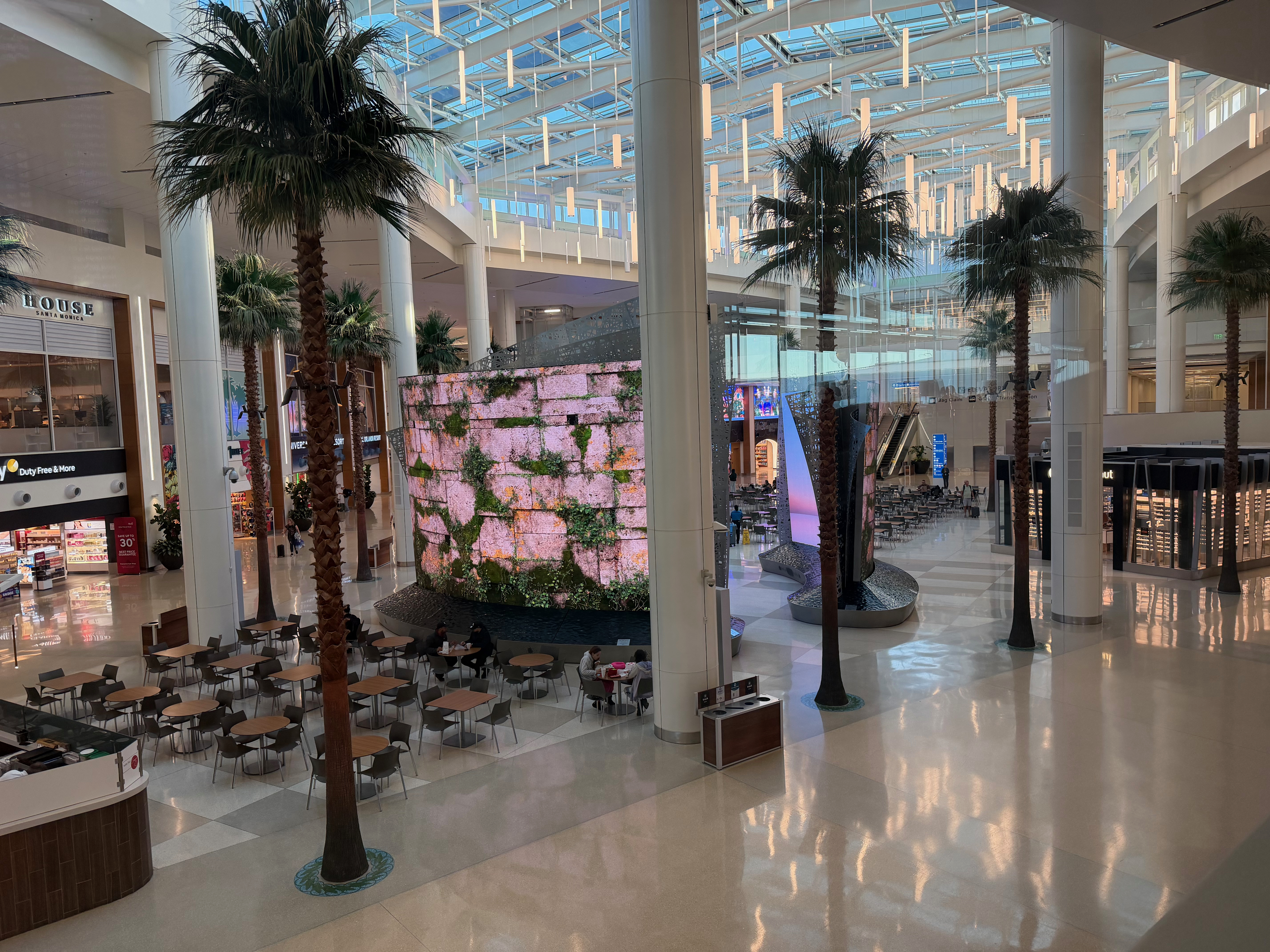 a large building with palm trees and a large screen