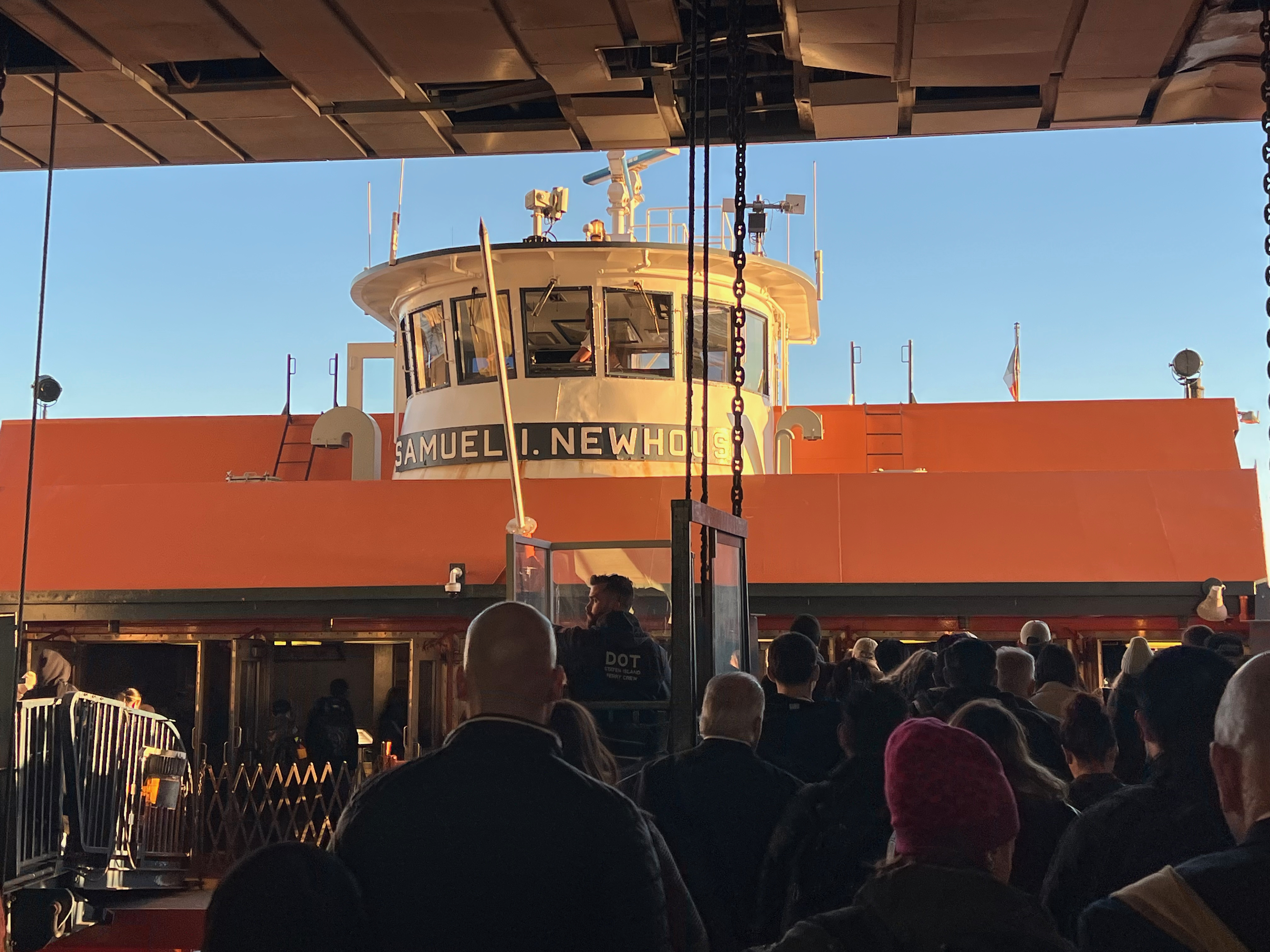 A group of people standing in front of the Staten Island Ferry