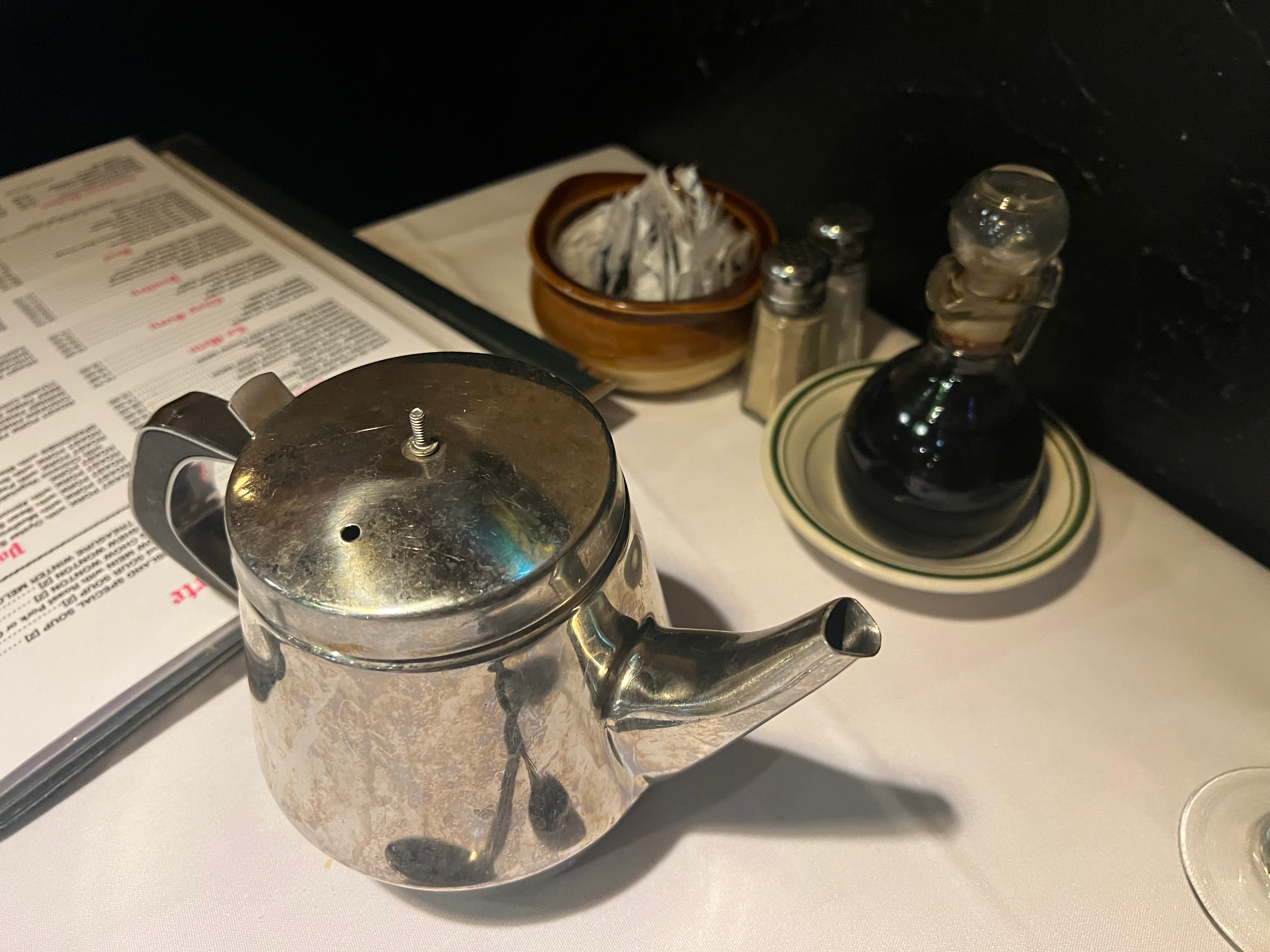 A metal teapot on the table