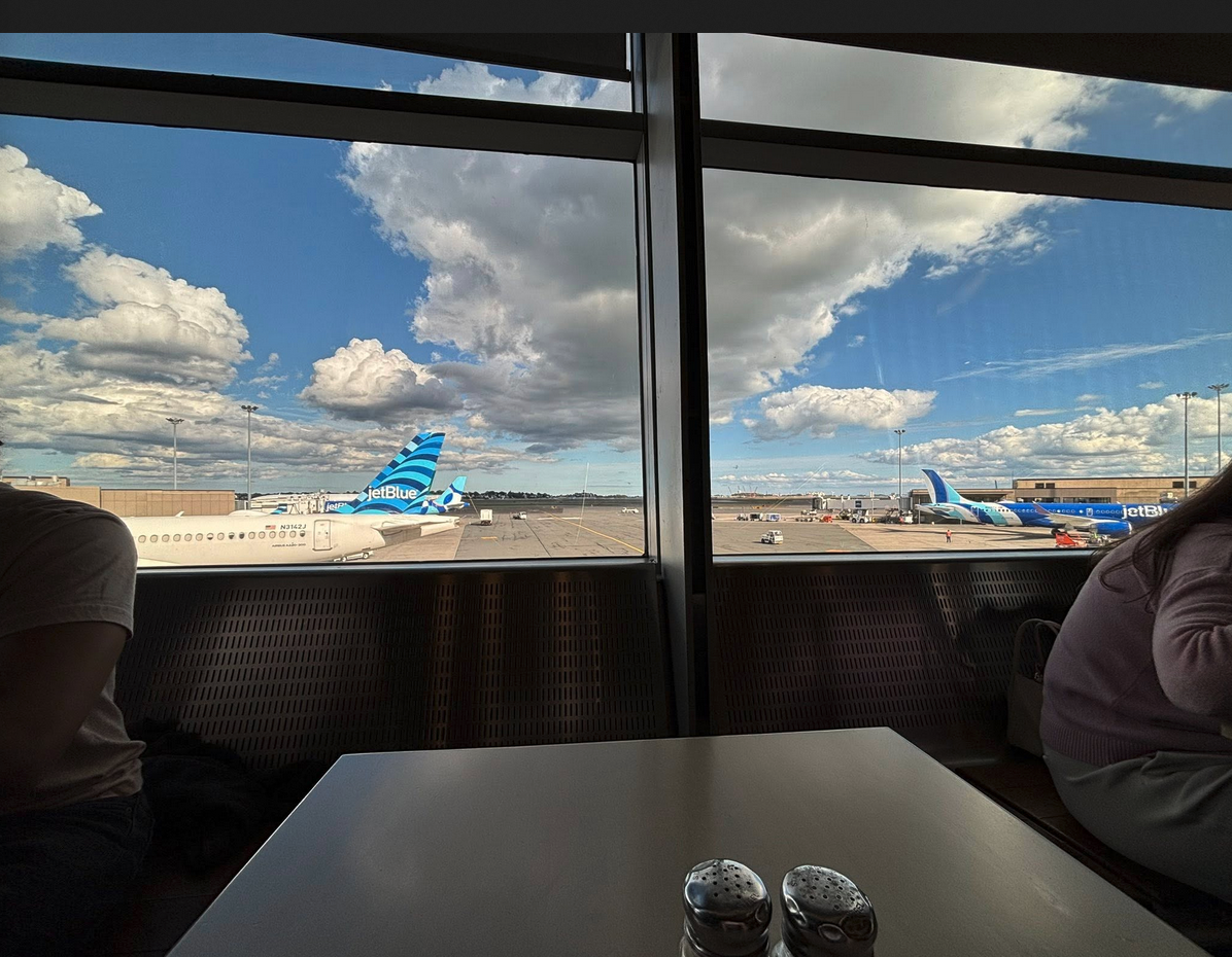 a couple of people sitting at a table in front of a window