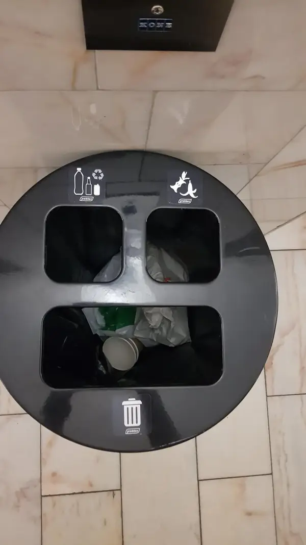 a black trash can with three holes