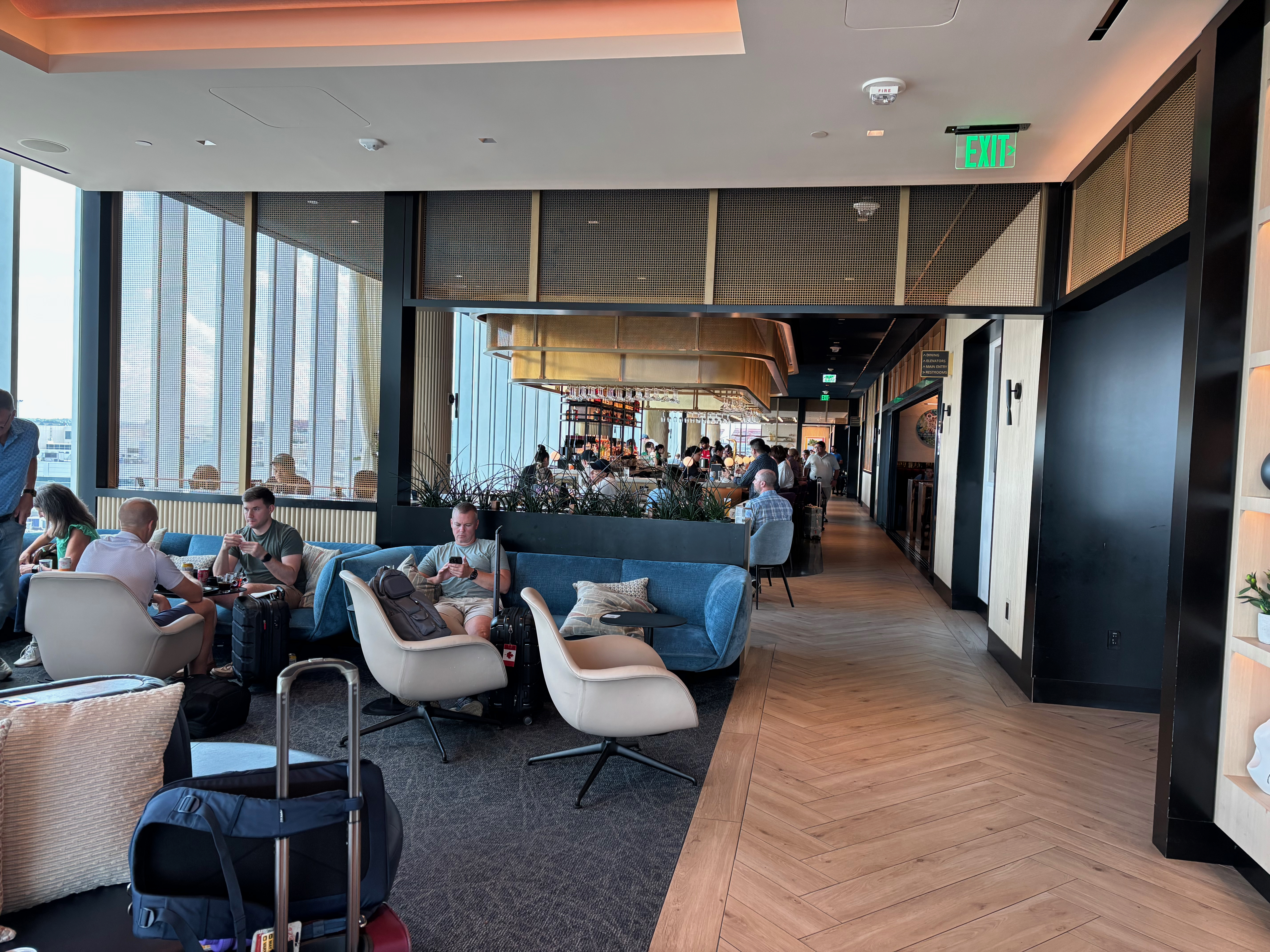 people sitting in a room with chairs and luggage