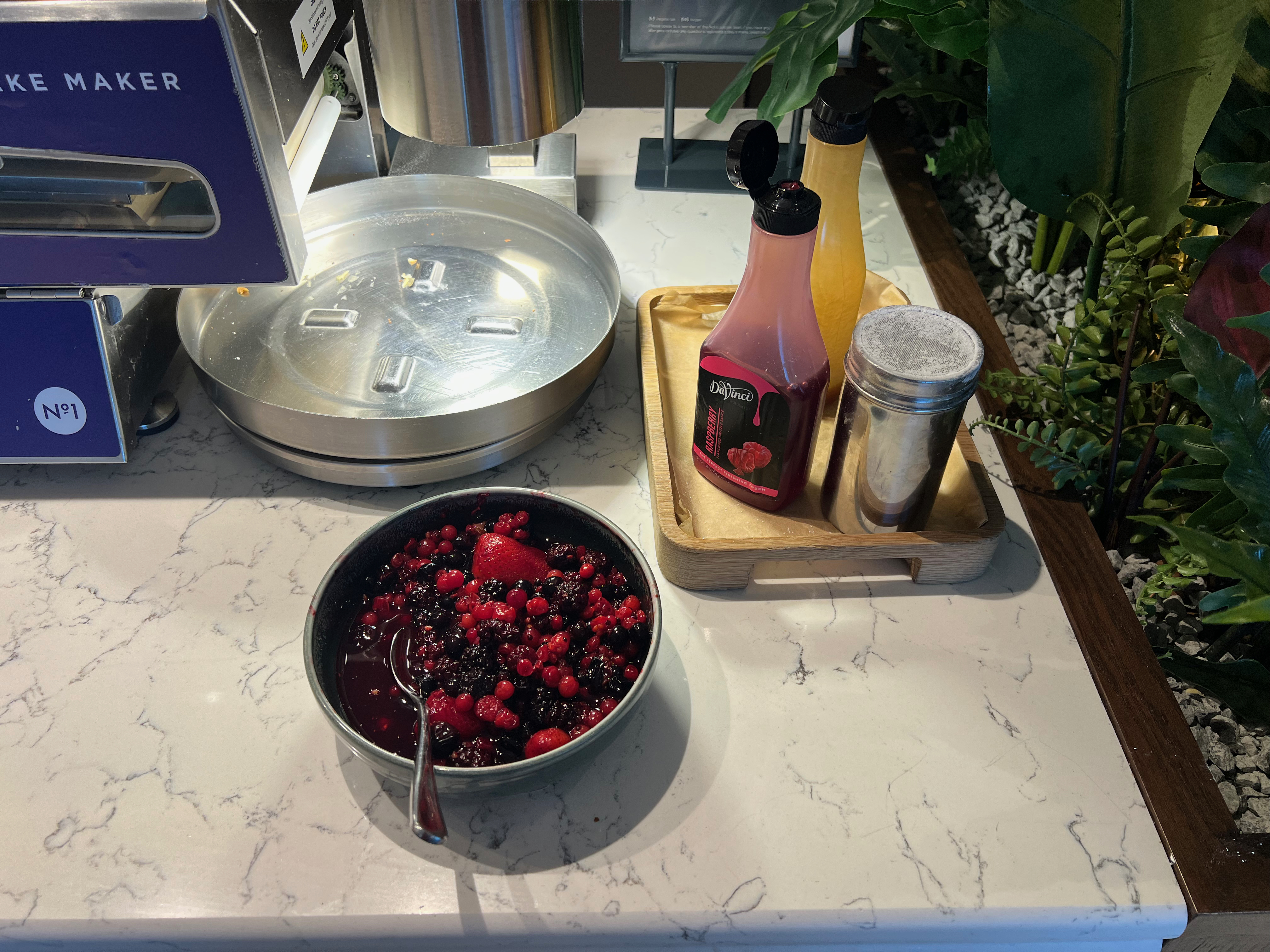 Pancake toppings and accompaniments set out next to the pancake machine