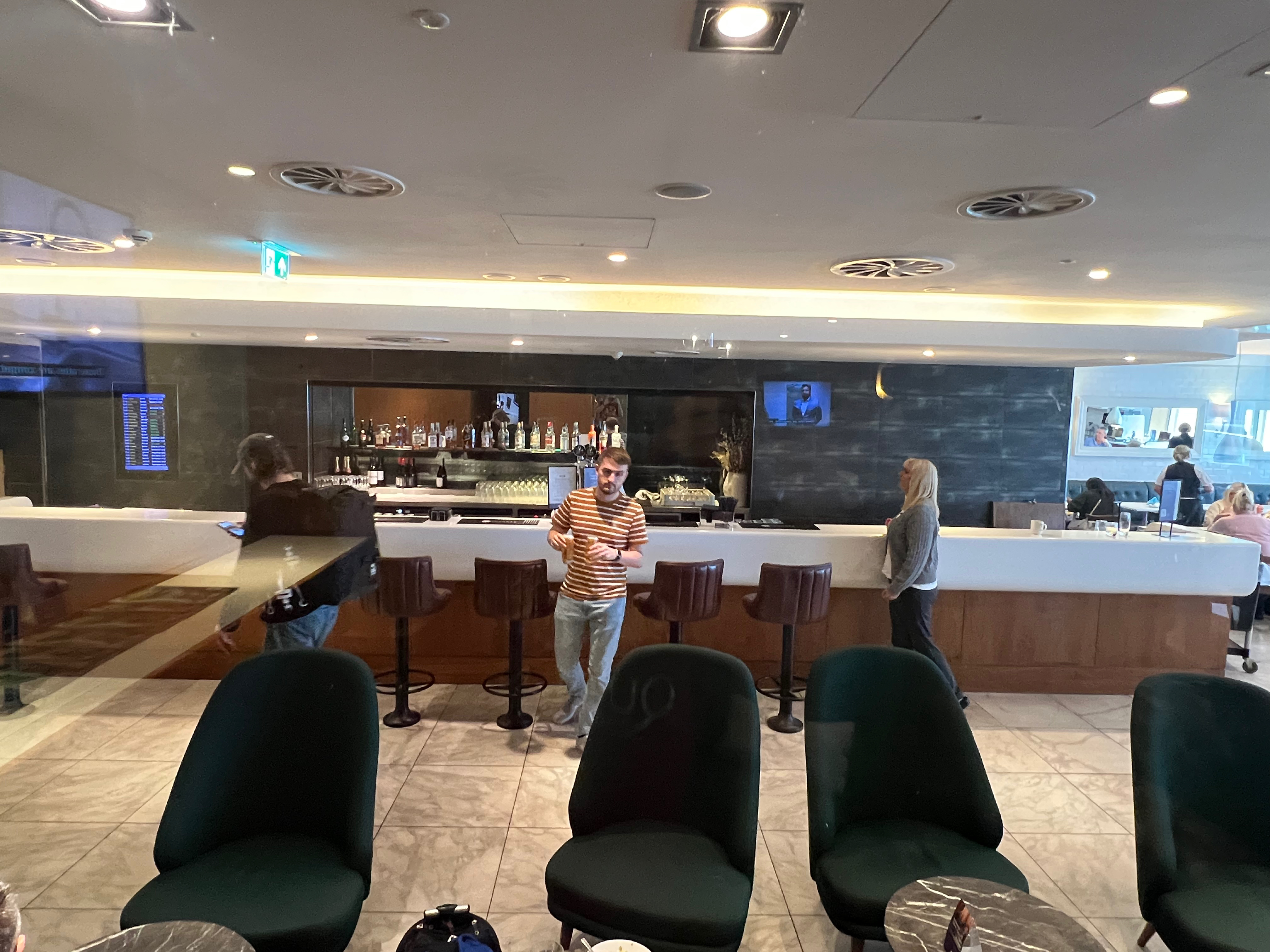 Lounge seating area with travelers standing and moving around