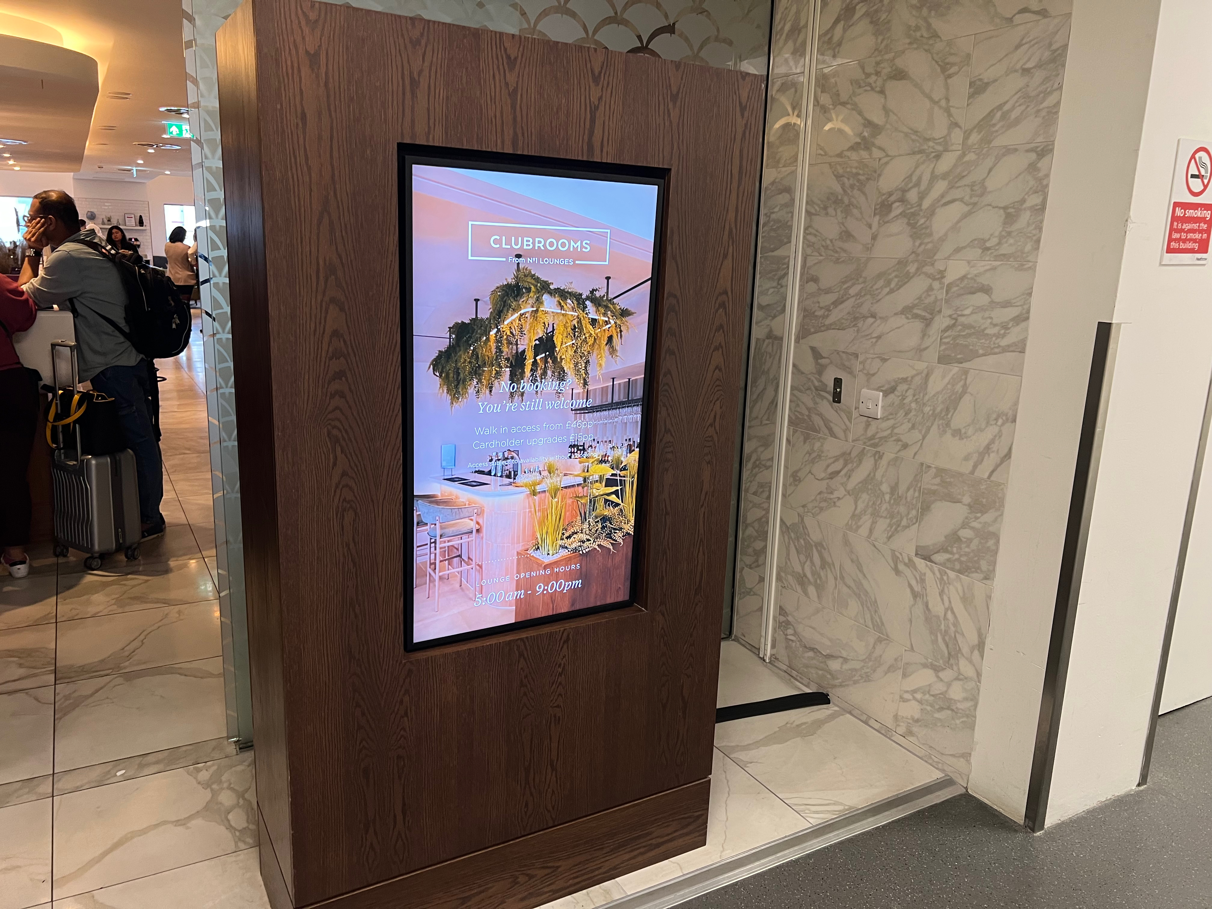 Digital display showing No1 Lounge hours and walk-in access information