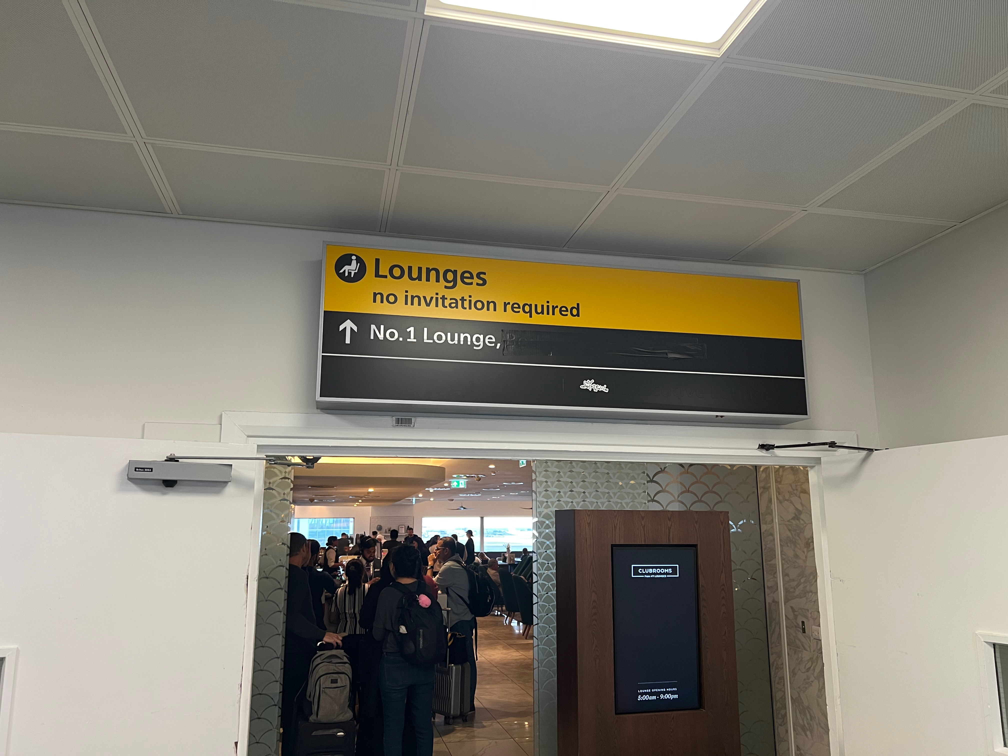 Signage above a doorway pointing travelers toward the No1 Lounge at Heathrow