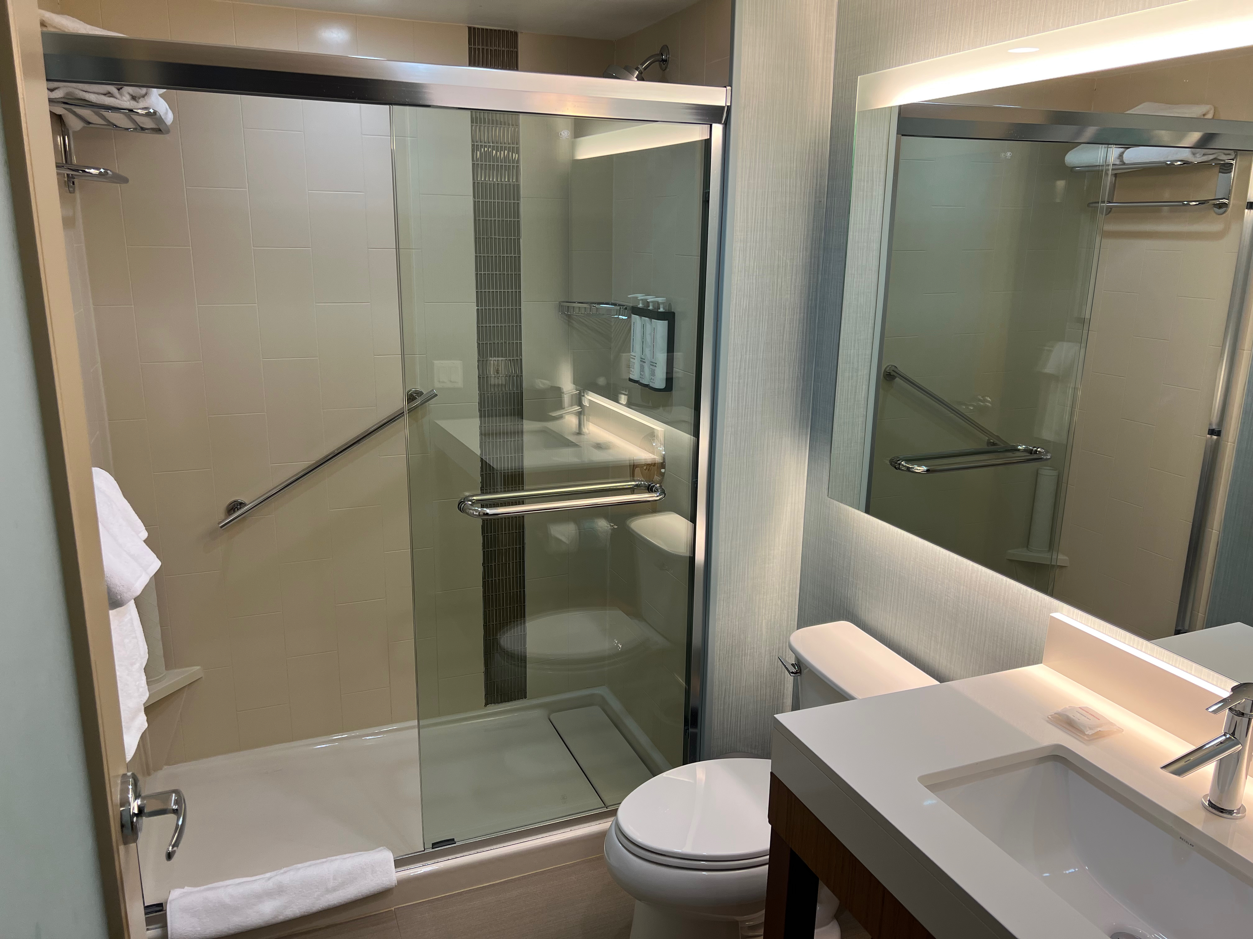 a bathroom with a glass shower door and sink